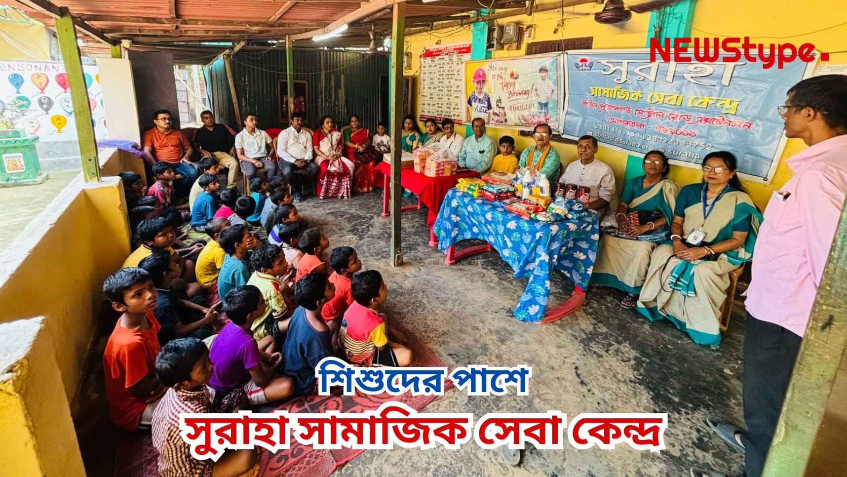 Suraha Social Service Center stands beside children.